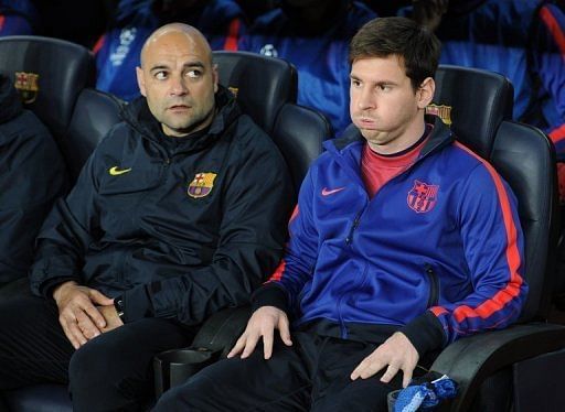 Barcelona's Lionel Messi (R) sits in the bench in Barcelona on April 10, 2013
